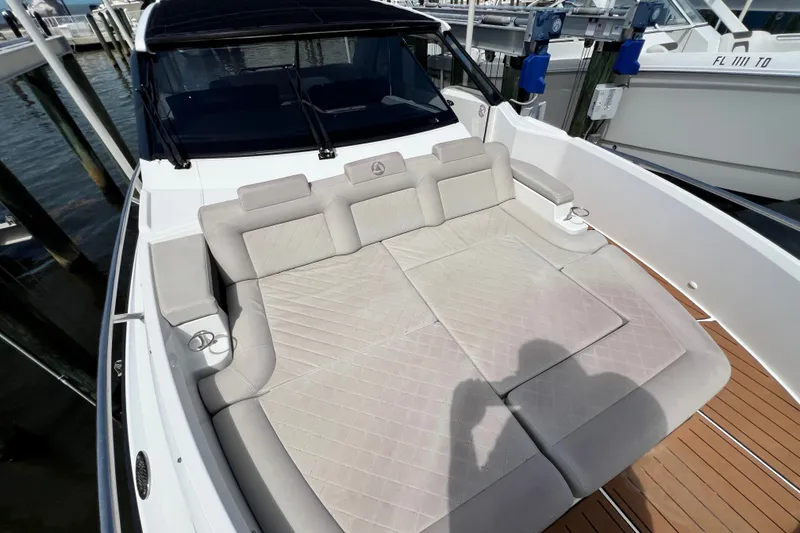 Slide: The Image of 2024 Skamander 100 Sorrento boat with spacious cushioned seating area at dock. - 102