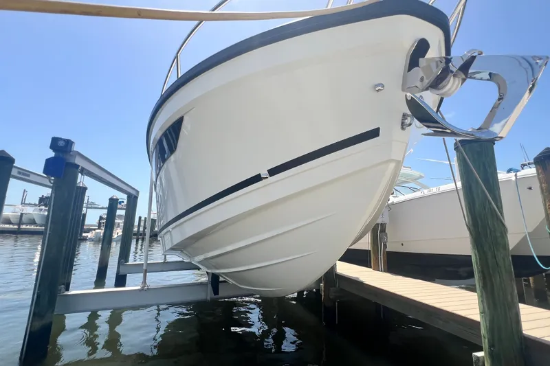 Slide: The Image of 2024 Skamander 100 Sorrento boat docked, showcasing sleek hull design and anchor. - 36