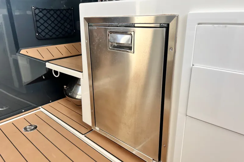 Slide: The Image of 2024 Skamander 100 Sorrento boat interior with stainless steel compartment and wooden flooring. - 150