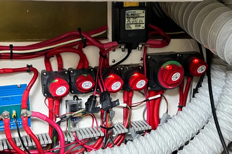 Slide: The Image of Electrical system with red cables and switches in a 2024 Skamander 100 Sorrento boat. - 158