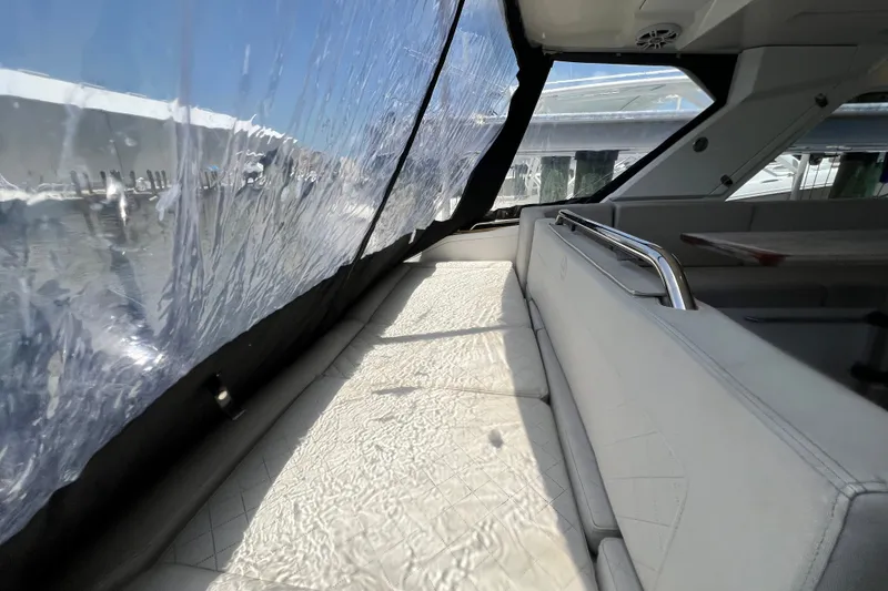 Slide: The Image of 2024 Skamander 100 Sorrento yacht interior with cushioned seating and clear window panels. - 60