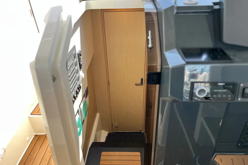 Slide: The Image of Interior view of 2024 Skamander 100 Sorrento boat, featuring control panel and wooden door. - 128
