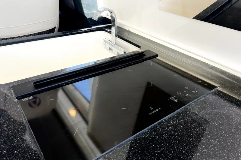 Slide: The Image of 2024 Skamander 100 Sorrento kitchen with sleek black induction cooktop and modern faucet. - 154