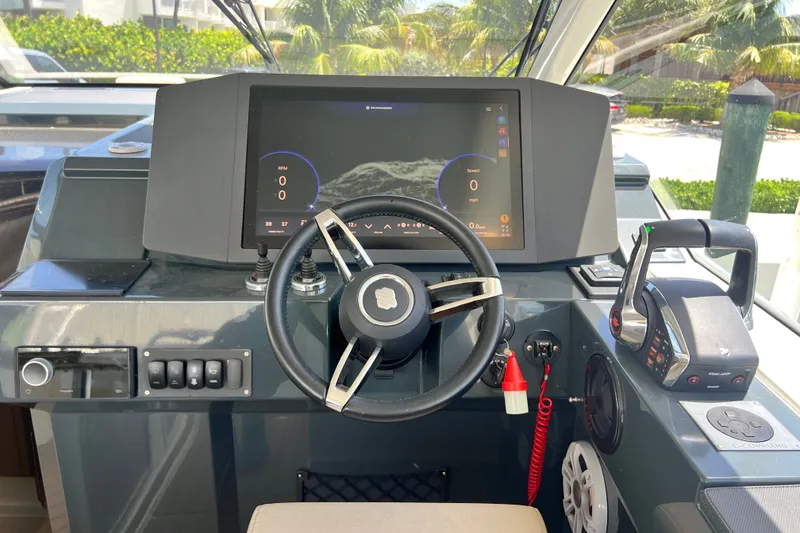 Slide: The Image of 2024 Skamander 100 Sorrento boat dashboard with steering wheel and digital display. - 114