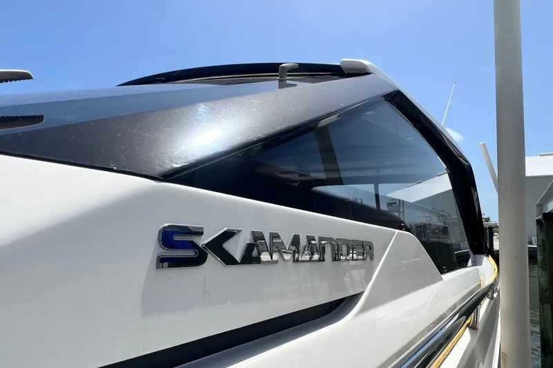 Slide: The Image of 2024 Skamander 100 Sorrento boat, sleek design, docked under clear blue sky. - 48