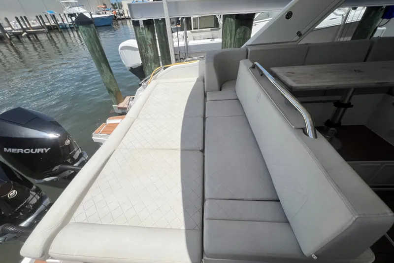 Slide: The Image of 2024 Skamander 100 Sorrento boat interior with cushioned seating and Mercury outboard engines. - 83