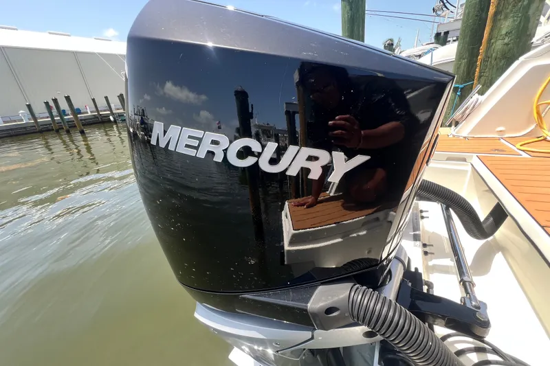 Slide: The Image of Outboard motor on 2024 Skamander 100 Sorrento boat, docked by the water. - 64