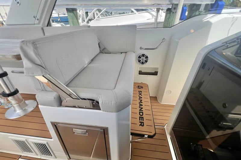 Slide: The Image of 2024 Skamander 100 Sorrento boat interior with cushioned seating and teak flooring. - 116