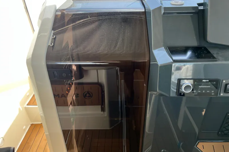Slide: The Image of 2024 Skamander 100 Sorrento boat interior with control panel and wooden flooring. - 126