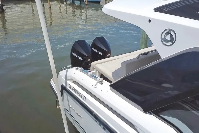 Slide: The Image of 2024 Skamander 100 Sorrento boat with dual Mercury engines docked by the water. - 22