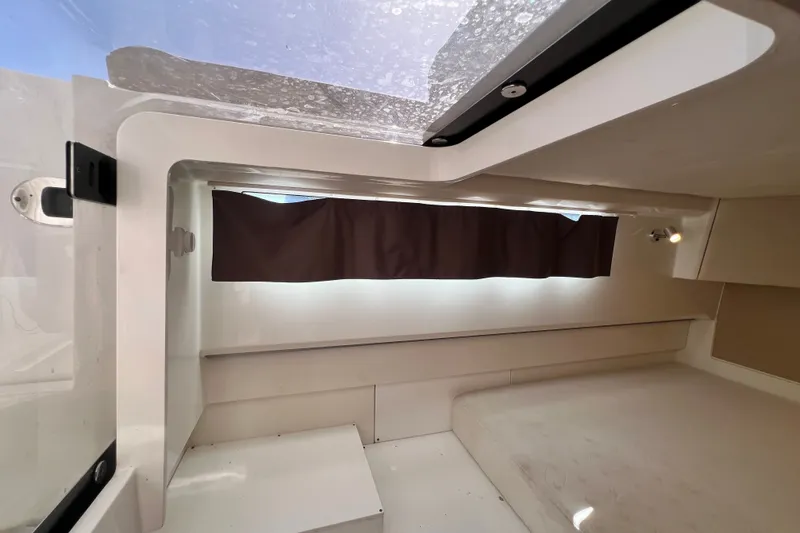 Slide: The Image of Interior cabin of 2024 Skamander 100 Sorrento boat, featuring a window with curtains. - 185