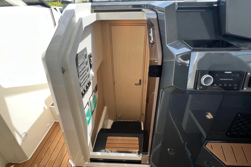 Slide: The Image of 2024 Skamander 100 Sorrento boat interior with control panel and wooden door. - 129