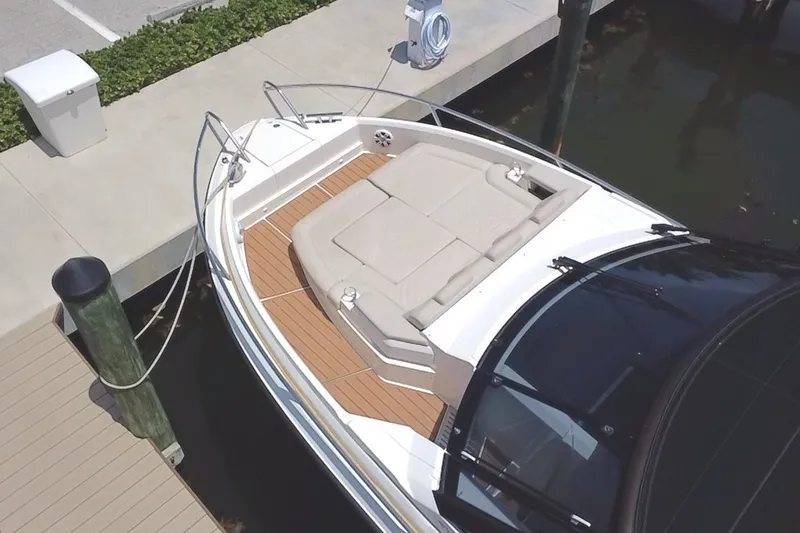 Slide: The Image of 2024 Skamander 100 Sorrento boat docked, featuring a spacious sunbathing area. - 13