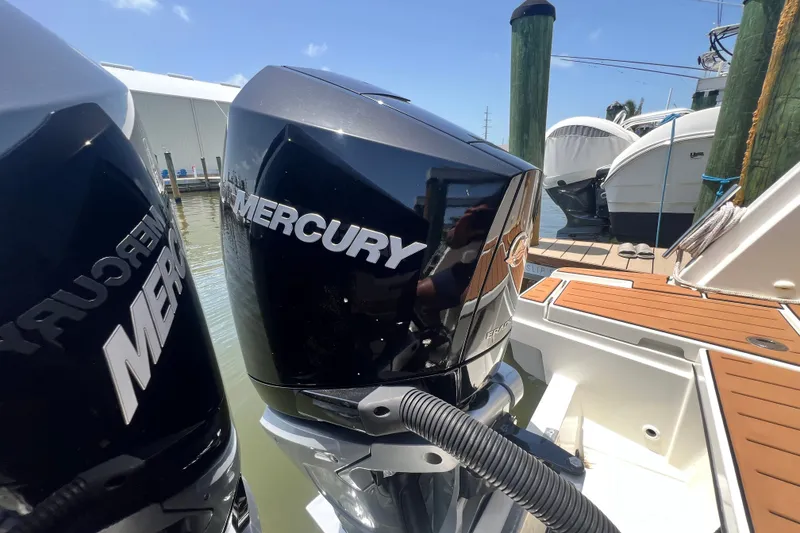 Slide: The Image of 2024 Skamander 100 Sorrento with Mercury outboard engines at a marina dock. - 65