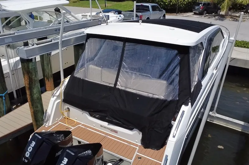 Slide: The Image of 2024 Skamander 100 Sorrento boat docked with covered rear deck and twin Mercury engines. - 20