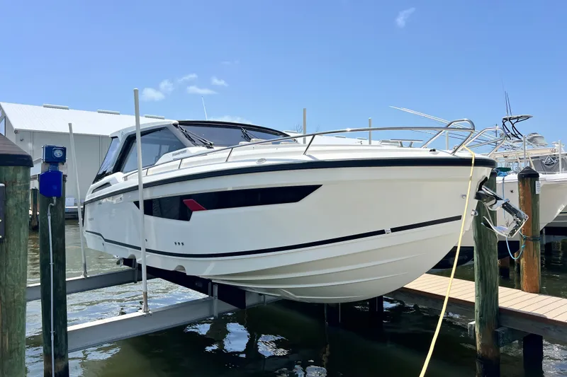 Slide: The Image of 2024 Skamander 100 Sorrento boat docked on lift under clear blue sky. - 29