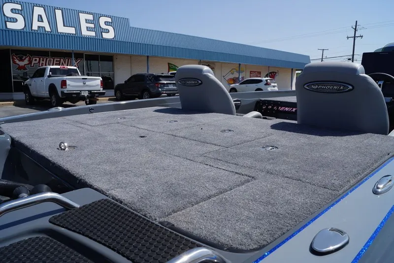 Slide: The Image of 2027 Phoenix 721 ZXL boat at dealership, featuring spacious carpeted deck and seating. - 13