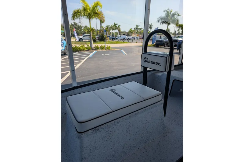 Slide: The Image of 2026 Gheenoe Lo Tide 25 boat interior with branded seating, parked outdoors. - 4