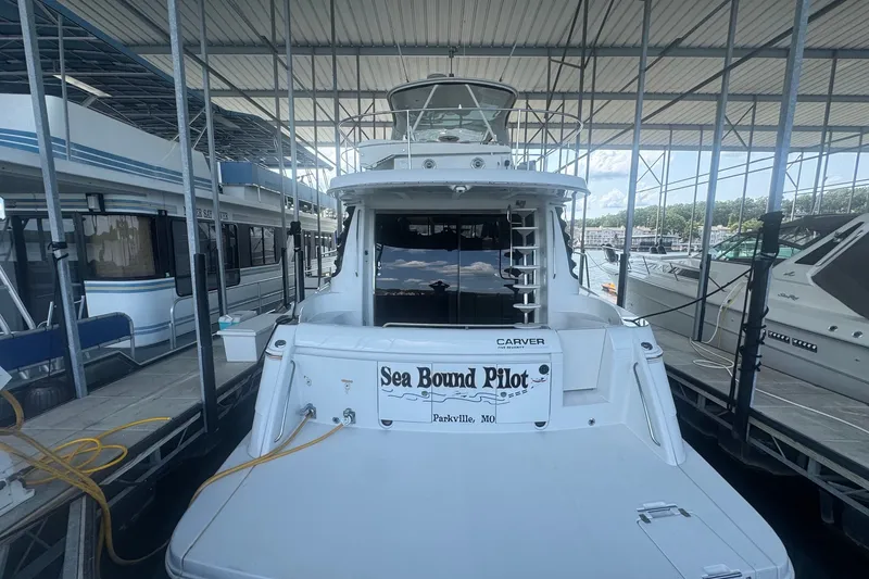 Slide: The Image of 2003 Carver 570 Voyager Pilothouse docked in a marina, rear view. - 11