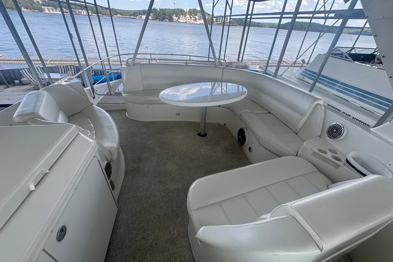Slide: The Image of 2003 Carver 570 Voyager Pilothouse yacht interior with spacious seating and table, overlooking water. - 15