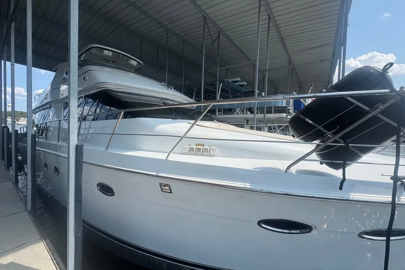 Slide: The Image of 2003 Carver 570 Voyager Pilothouse yacht docked under a covered marina. - 13