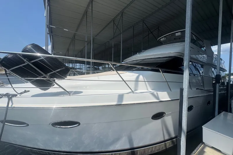 Slide: The Image of 2003 Carver 570 Voyager Pilothouse yacht docked under a covered marina. - 10