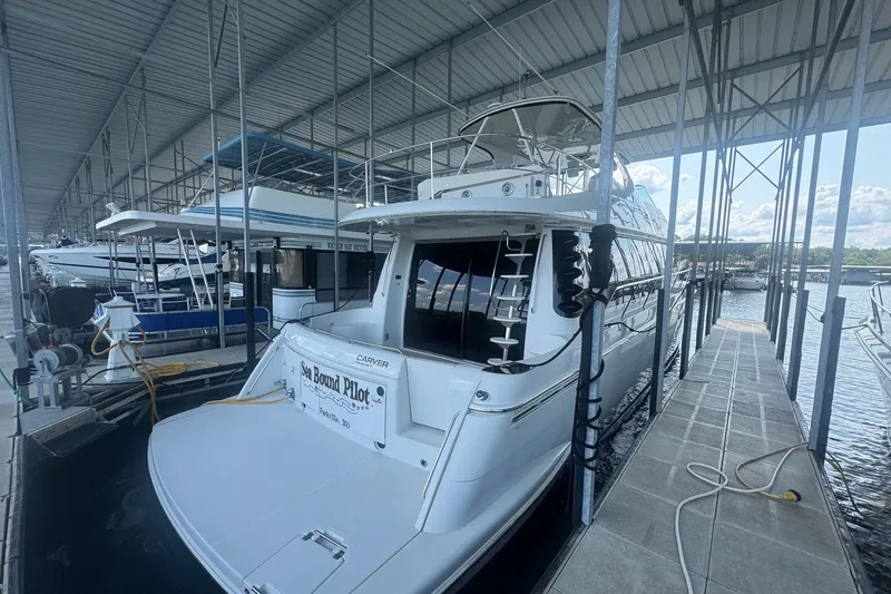 Slide: The Image of 2003 Carver 570 Voyager Pilothouse docked in a marina under a covered structure. - 12