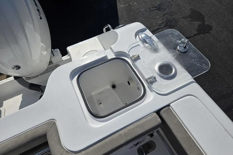Slide: The Image of 2026 Sea Hunt Gamefish 25 boat deck with open storage compartment and motor. - 16