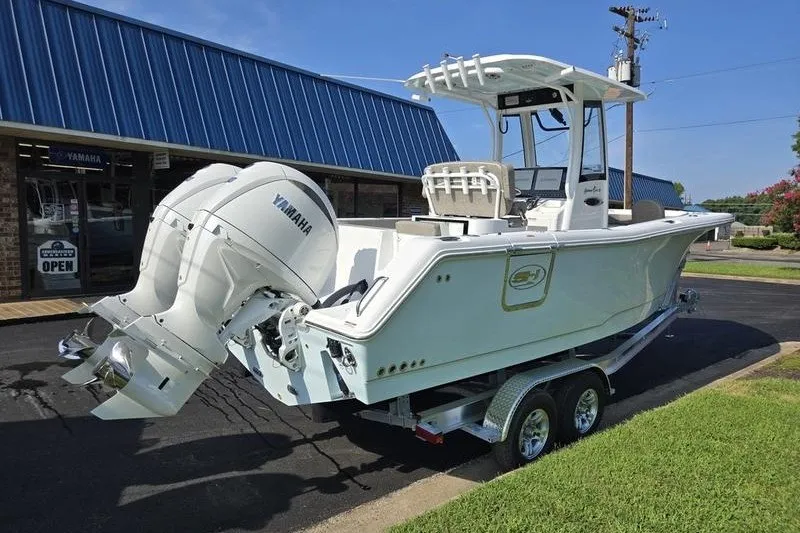 Slide: The Image of 2026 Sea Hunt Gamefish 25 boat with dual Yamaha engines on a trailer. - 14