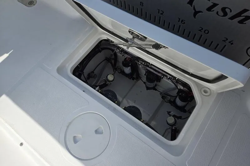 Slide: The Image of 2026 Sea Hunt Gamefish 25 boat compartment with open hatch, showcasing internal components. - 20