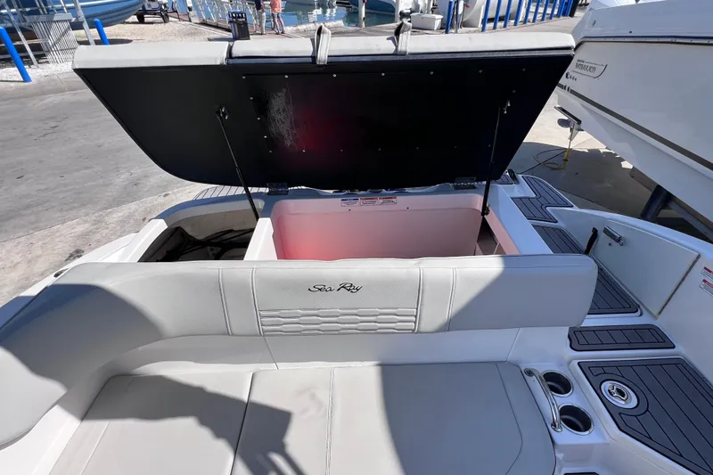 Slide: The Image of 2022 Sea Ray SPX 210 Outboard boat with open storage compartment and seating area. - 23