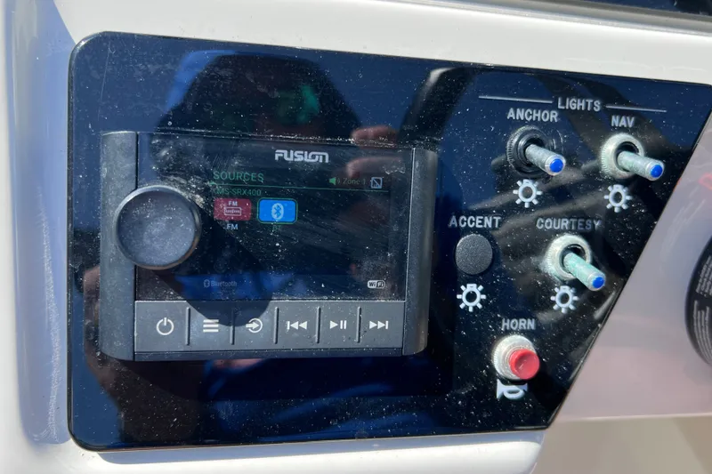 Slide: The Image of Control panel of a 2022 Sea Ray SPX 210 Outboard boat with audio and light switches. - 32