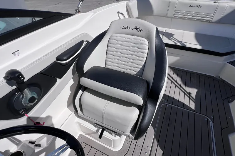 Slide: The Image of 2022 Sea Ray SPX 210 Outboard boat interior with cushioned seating and steering controls. - 19