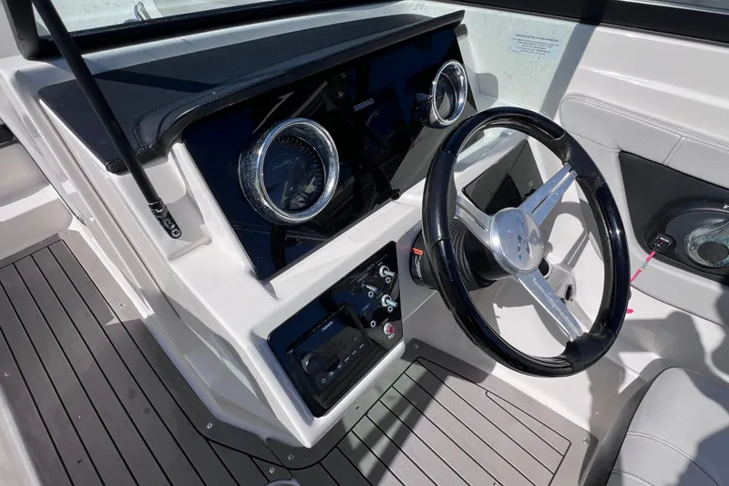 Slide: The Image of 2022 Sea Ray SPX 210 Outboard dashboard with steering wheel and controls. - 22