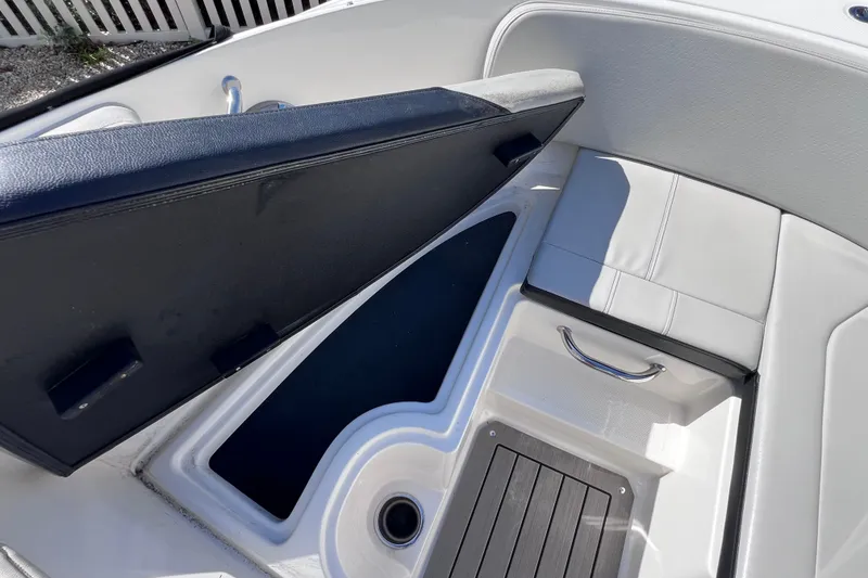 Slide: The Image of 2022 Sea Ray SPX 210 Outboard boat interior storage compartment with cushioned seating. - 28