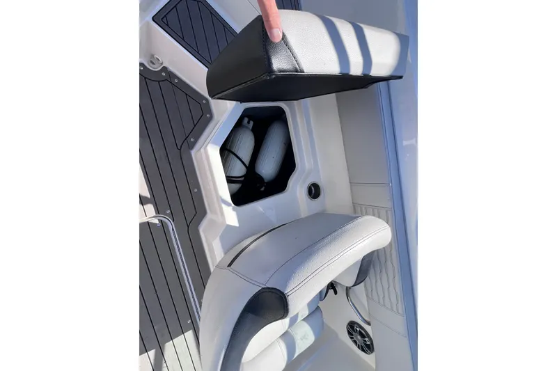 Slide: The Image of 2022 Sea Ray SPX 210 Outboard boat seat storage compartment with safety equipment. - 16