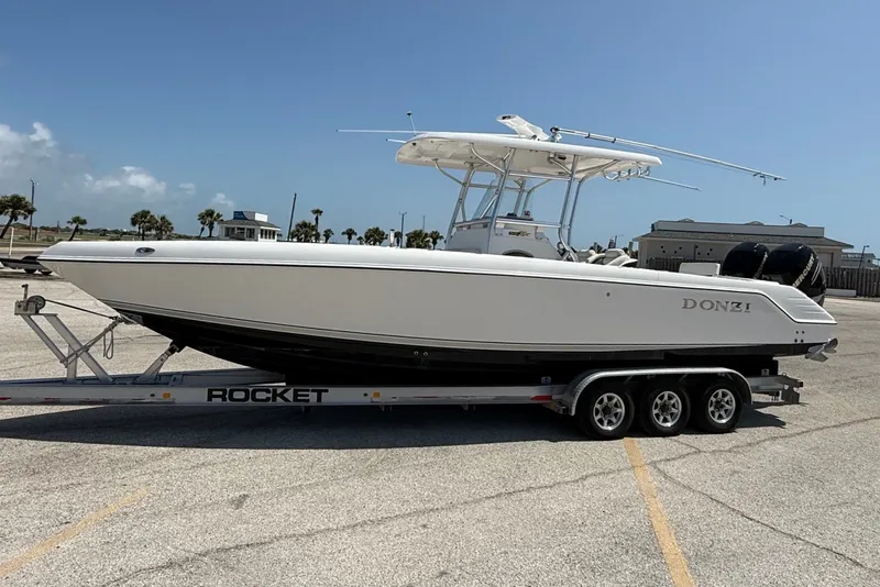 Slide: The Image of 2010 Donzi 32 ZF boat on a trailer in a parking lot under clear skies. - 2