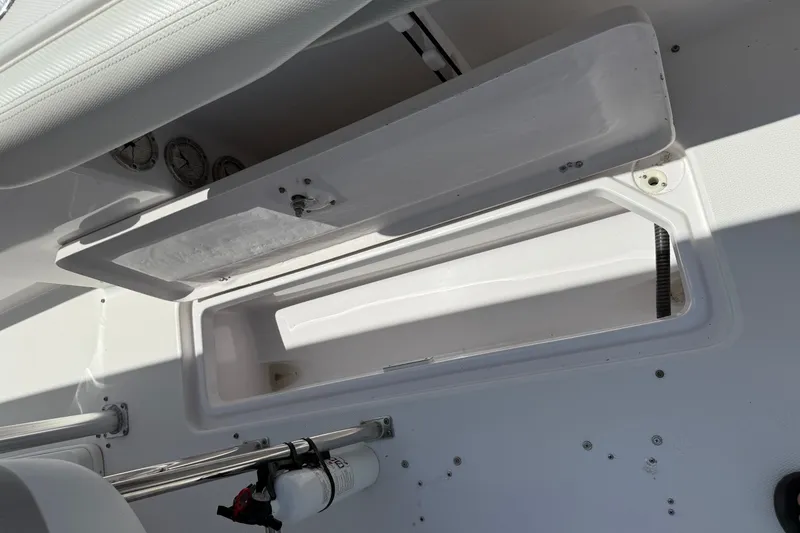 Slide: The Image of Open storage compartment on a 2010 Donzi 32 ZF boat, featuring gauges and a fire extinguisher. - 14