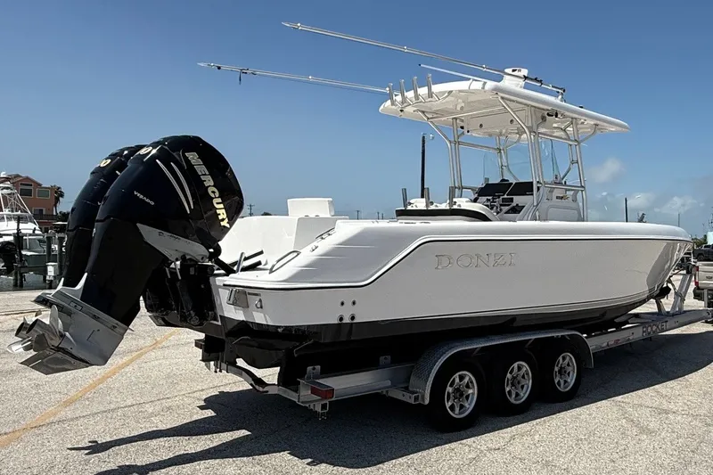 Slide: The Image of 2010 Donzi 32 ZF boat on trailer with dual Mercury engines, parked outdoors. - 1