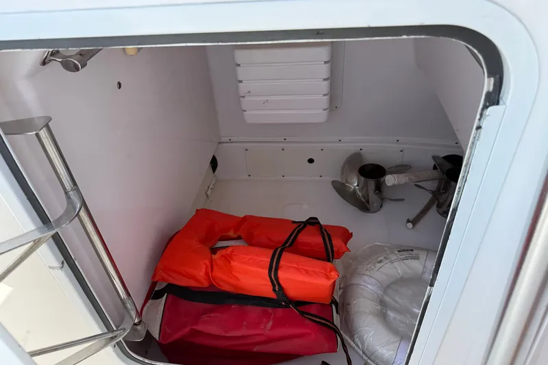 Slide: The Image of Storage compartment of a 2010 Donzi 32 ZF boat with life jackets and anchor. - 17