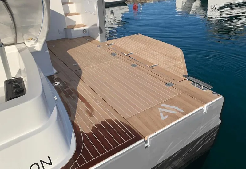 Slide: The Image of Aventura 38 Sport Coupe 2025 yacht with sleek wooden deck by the water. - 3