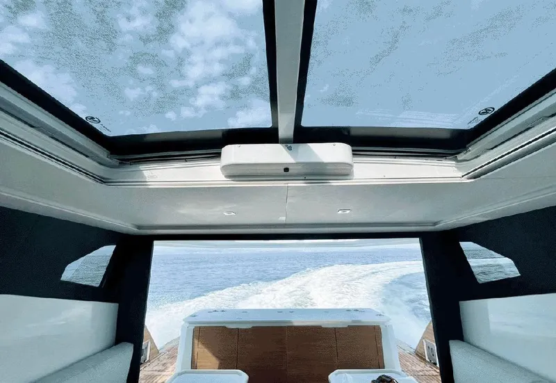 Slide: The Image of Interior view of 2025 Aventura 38 Sport Coupe with panoramic sunroof and ocean backdrop. - 5