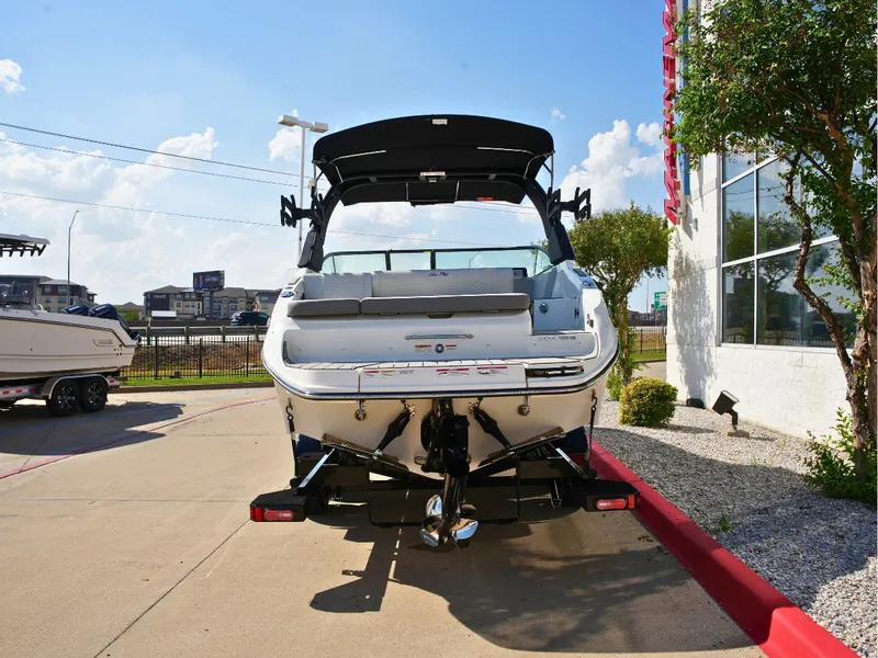 Slide: The Image of The image shows a 2027 Sea Ray SDX 250 Surf boat parked on a concrete lot. - 3
