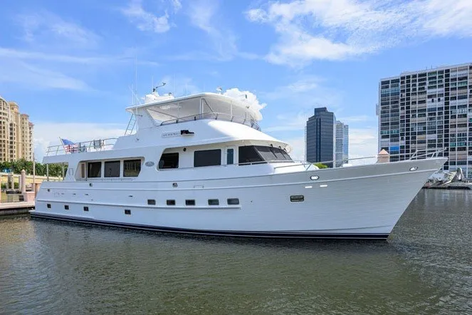 The Image of 2008 Outer Reef Yachts 800 Motoryacht docked in a marina with cityscape background. - 0