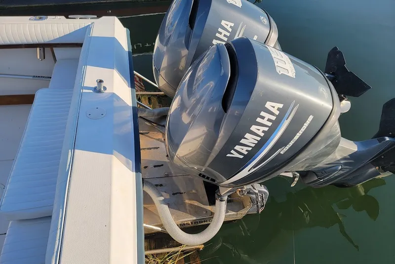 Slide: The Image of 1985 Grady-White Offshore Pro 247 with twin Yamaha outboard motors, docked on calm water. - 10