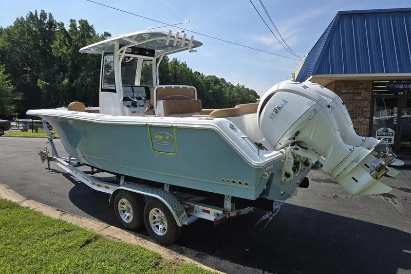 Slide: The Image of 2027 Sea Hunt Ultra 275SE boat on trailer, parked outdoors near a building. - 6