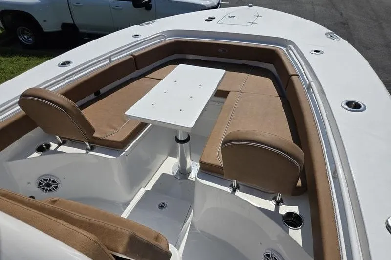 Slide: The Image of 2027 Sea Hunt Ultra 275SE boat interior with tan seating and a central table. - 8