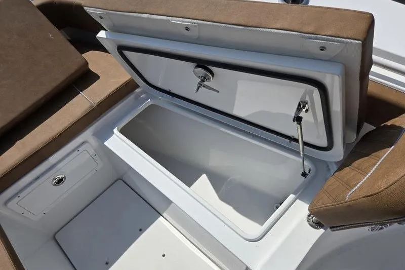 Slide: The Image of Open storage compartment on 2027 Sea Hunt Ultra 275SE boat with brown seating. - 13