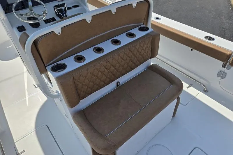 Slide: The Image of 2027 Sea Hunt Ultra 275SE boat interior with brown cushioned seating and cup holders. - 18