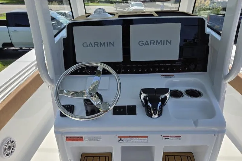 Slide: The Image of 2027 Sea Hunt Ultra 275SE boat dashboard with Garmin displays and steering wheel. - 22